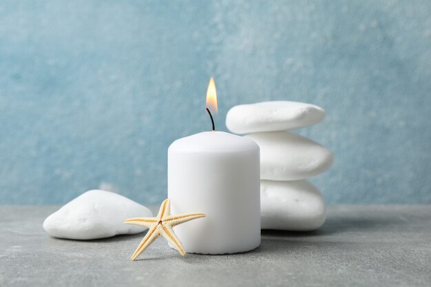 Sea stones, candle and seastar on grey background, copy space. Spa concept