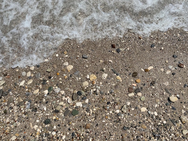 海の石とビーチの夏の背景の波