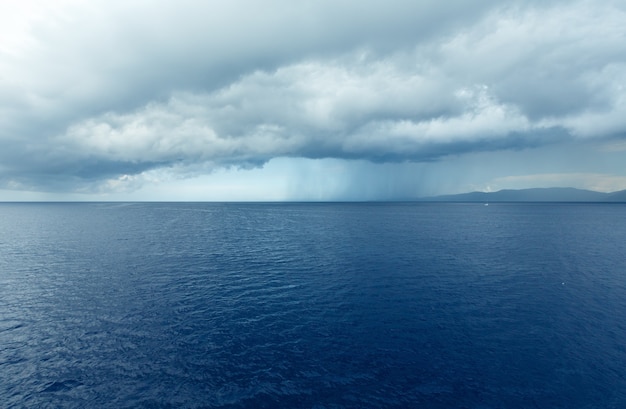 Sea summer view (with stormy sky and rain on horizon) from train ferry on way from Kefalonia to Ithaca(Greece)