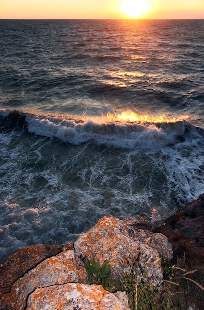 Sea sunset with surf and rocky coast