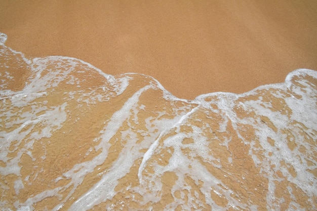 Photo sea surf wave over beach sand