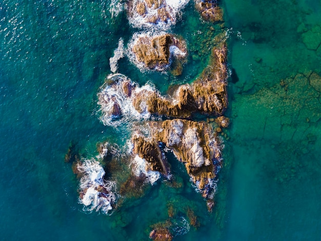 Вид на море сверху с водой на переднем плане и скалами на переднем плане.