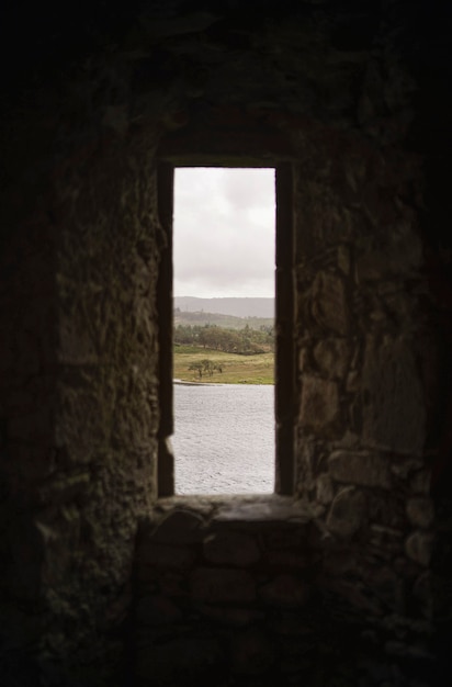 스코틀랜드 킬춘 성(Kilchurn Castle)의 바위 창문을 통한 바다 전망