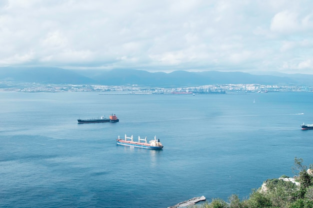 Photo sea view with cargo ships from gibraltar rock spanish port of algeciras and the british colony gibraltar