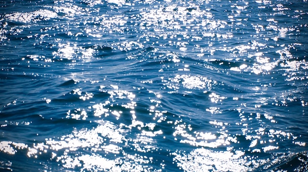 Sea water blue surface sun light flashes background  high quality photo