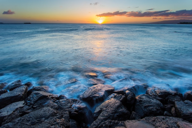 Sea wave hit the rock at sunset in Hawaii