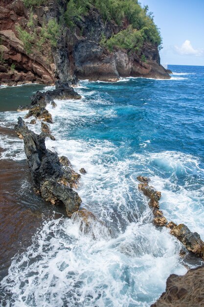 海の波と岩、夏のビーチの背景。