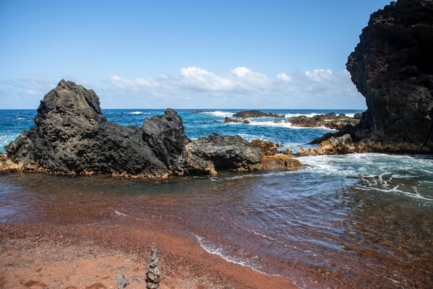 海の波と岩の夏のビーチの背景