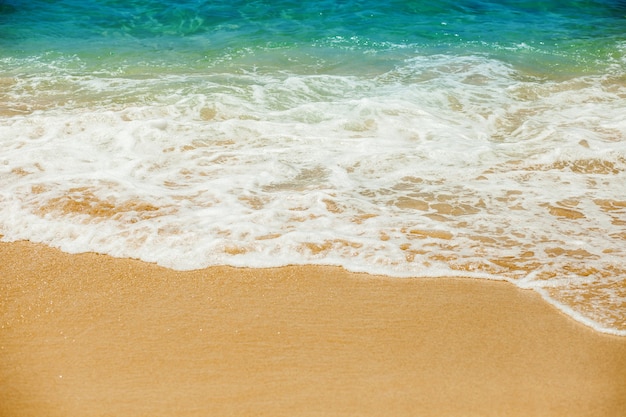 Onda del mare alla spiaggia sabbiosa