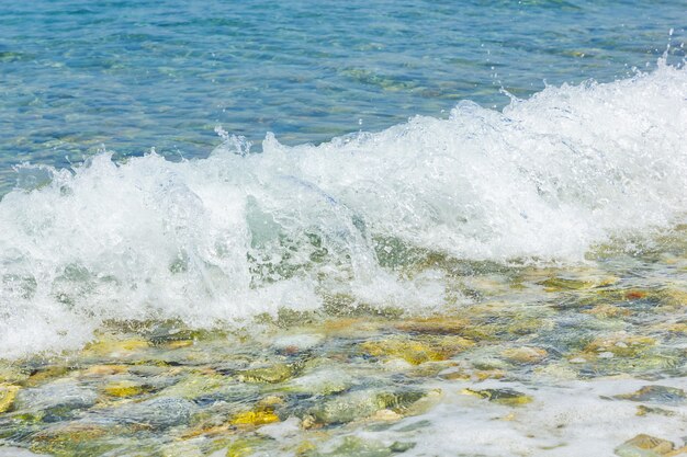 Sea wave with foam and pebbles