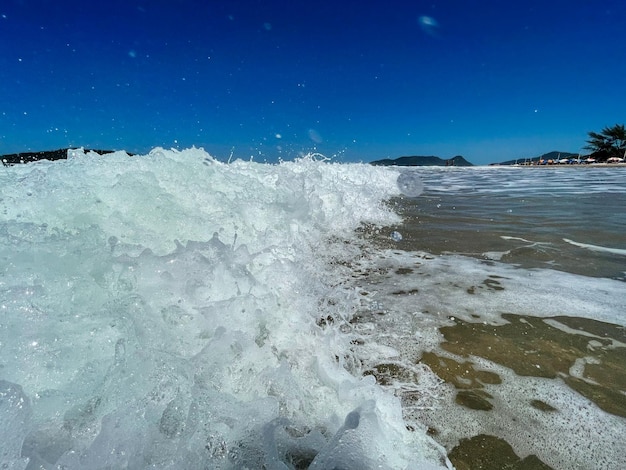 Sea waves on the beach sand in summer day blue sky beautiful landscape