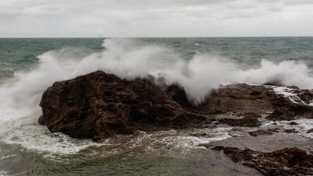 写真 海の波が冬に岩に激しくぶつかる