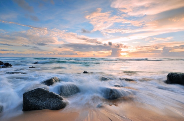 Sea waves lash line impact rock on the beach