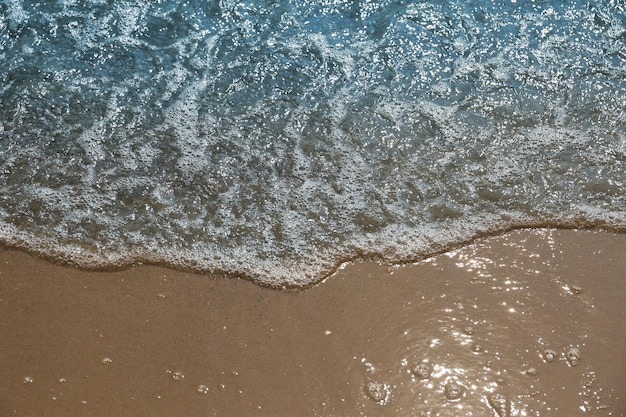 Морские волны накатывают на красивый песчаный пляж