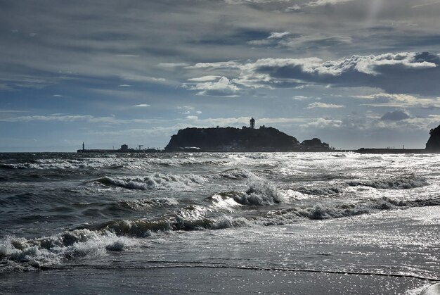 Foto le onde del mare si precipitano verso la riva contro il cielo