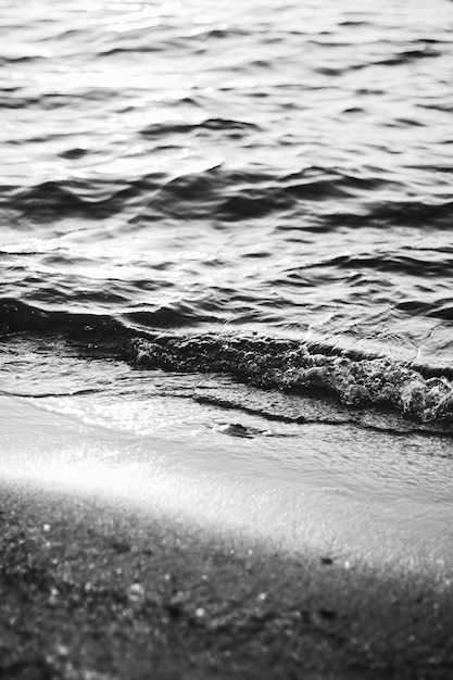 海の波と太陽の光の砂が夕日の黒と白のアートプリント砂浜と沿岸の自然に輝きます