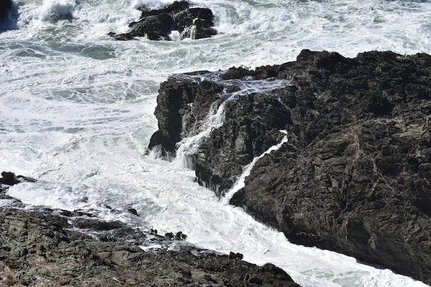 Фото Морские волны брызгают по скалам.