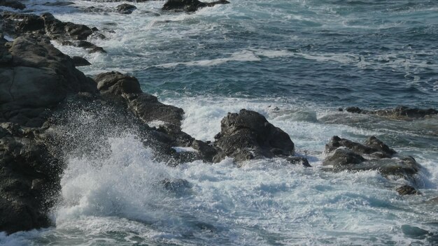 Foto le onde del mare che schizzano sulle rocce