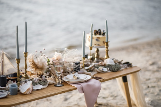 Photo sea wedding decor on the coast. wedding cake and flowers at the event.