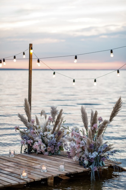 Фото Морской свадебный декор на побережье. вечерняя свадебная церемония у воды