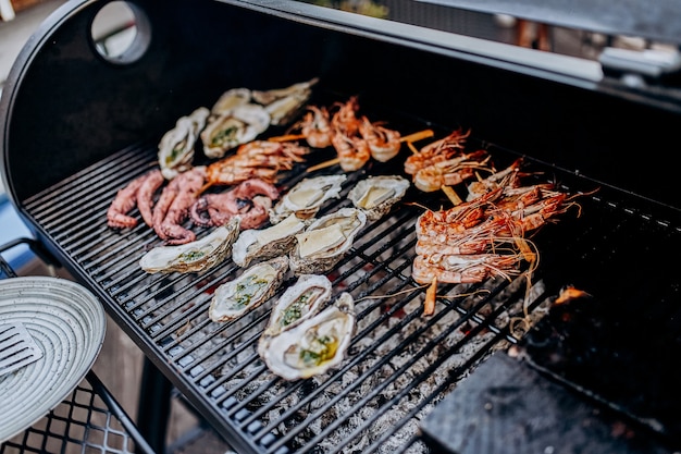Seafood BBQ  barbecue. Collection of octopus, oysters, clam, tiger shrimps grilled on grill
