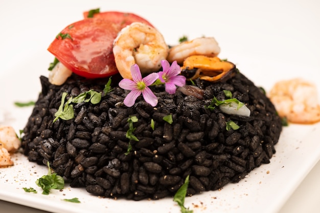 Seafood black Risotto with shrimps colored with Squid ink on white