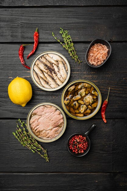 Seafood canned fish mussels food set, on black wooden table background, top view flat lay, with copy space for text