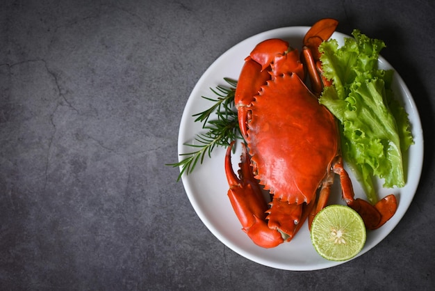 Photo seafood crab cooking food boiled or steamed crab red in the seafood restaurant fresh crab on white plate dark background top view