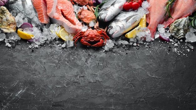 Photo seafood dorado salmon crab grouper oysters on a black stone background top view free space for your text