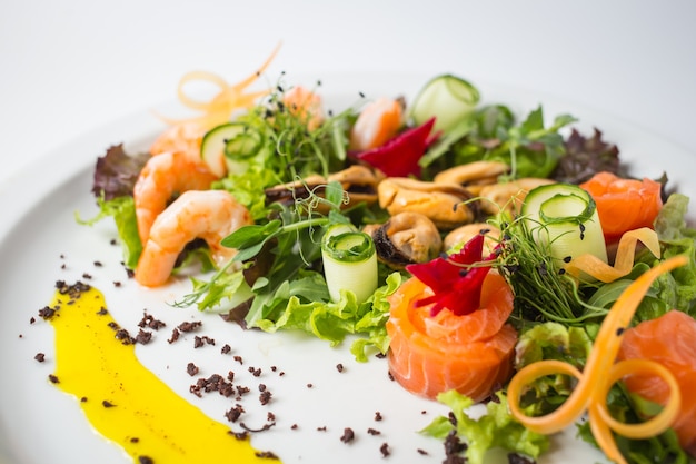 Seafood fresh salad with shrimps, mussels, salmon, green and cucumber.