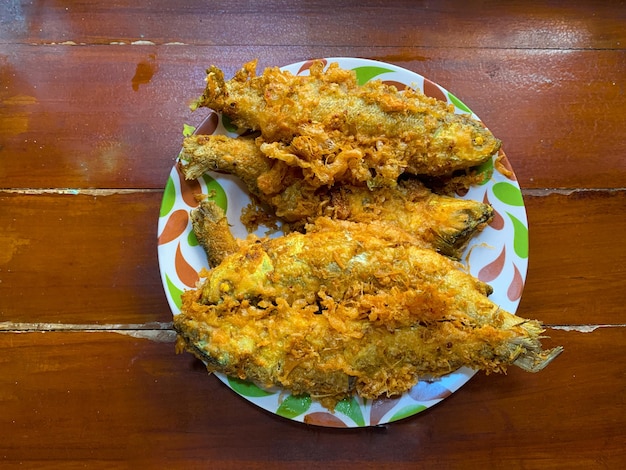 seafood fried fish in a plate cooked for lunch meal on wooden table bandeng presto or fried milk