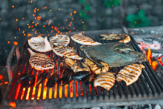 Seafood on the grill. Mussels, shrimp, squid and fish are cooked on fire.