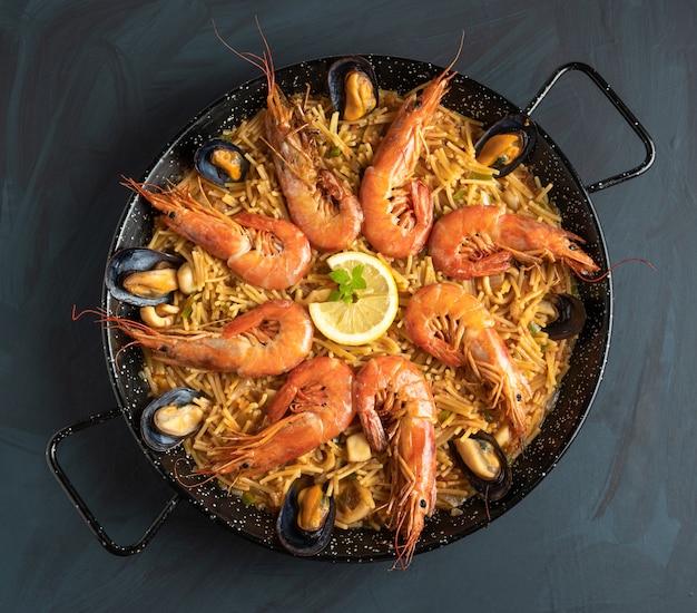 Seafood noodles on rustic wooden background, top view - fideua