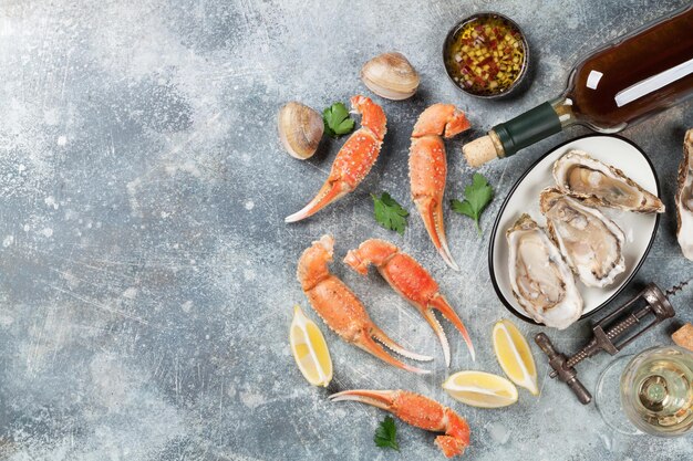 Photo seafood. oysters, lobster, clams and white wine. top view on stone table with space for your text