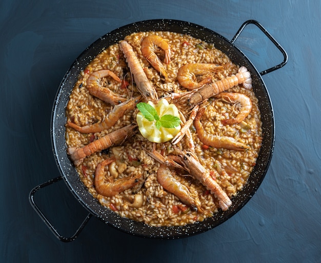 Seafood paella on wooden background