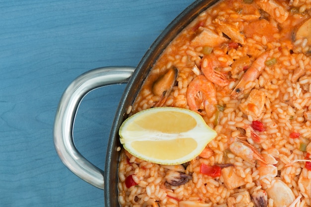 Seafood paella on a wooden blue background