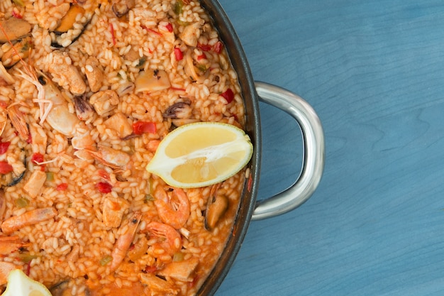 Seafood paella on a wooden blue background