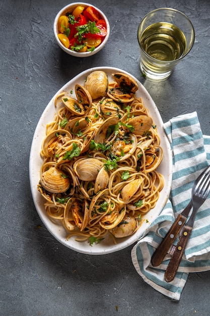 Макароны из морепродуктов итальянские спагетти alle vongole моллюски спагетти на белой тарелке с белым вином серого цвета