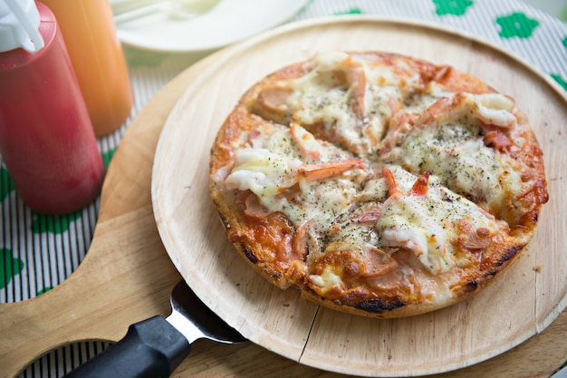 seafood pizza that combined with shrimp crap and squid on wooden plate and pizza paddle