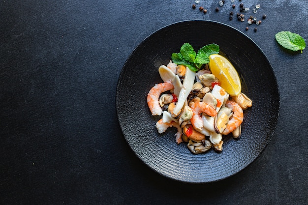 Seafood salad assortment on a black plate