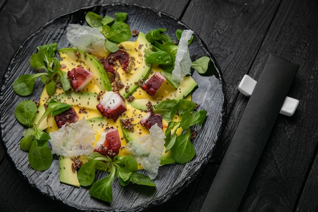 Seafood salad on a dark plate and wooden table