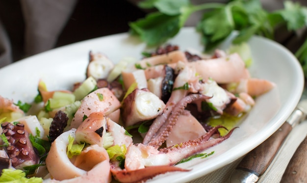 Seafood salad made of different seafood and vegetables, close up