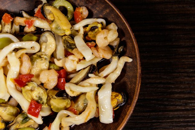Seafood salad with shrimp squid and mussels on wooden table