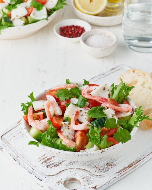 Insalata di mare con calamari, gamberi, cetrioli, pomodori e lattuga. lchf, fodmap, dieta paleo.