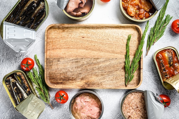 Seafood snacks - canned sardines, mussels, octopus, salmon and tuna. Gray background.