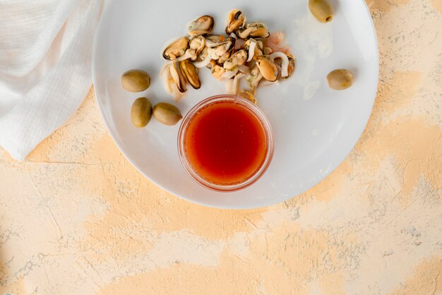 Seafood such as shrimps, octopuses and mussels and special sauce in a glass cups