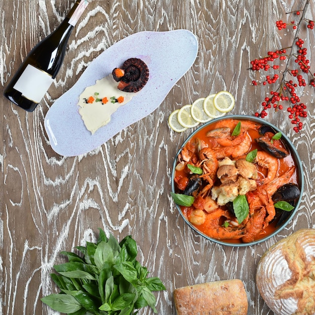 Seafood in tomato sauce with herbs. Shrimps, mussels, crayfish in red sauce on a wooden table
