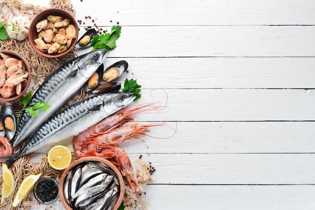 Seafood on a white wooden background. Fresh fish, shrimp, oysters and caviar. Top view. Free copy space.