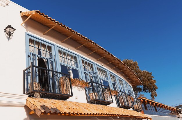 Seafront mediterranean cafe with white walls and light blue windows in setting sun