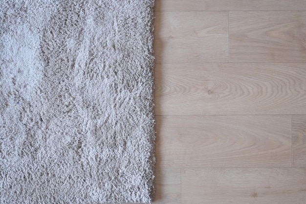 Seamless grey carpet texture background on wooden floor with copy space